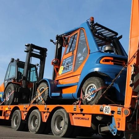 Orange-blauer Schwertransport befördert Gabelstapler