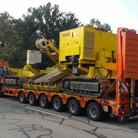 Schwerer Lastwagen transportiert große Maschine